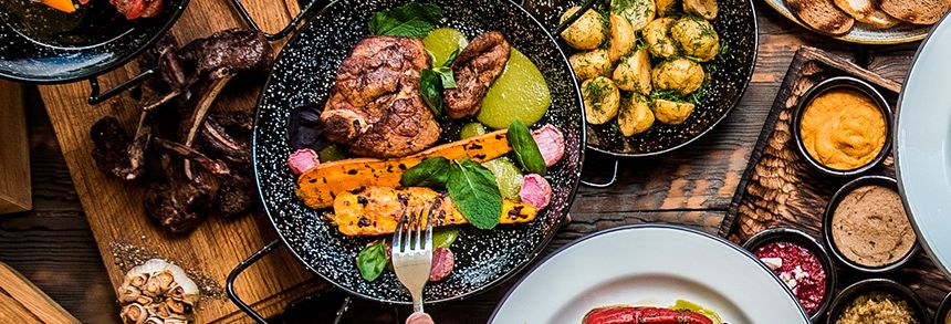 Gegrild vlees en gegrilde groenten in gietijzeren pannen, klaar voor de barbecue