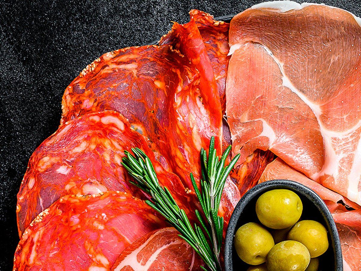 Schotel met fijne vleeswaren: chorizo, salami en gedroogde ham met olijven en rozemarijn